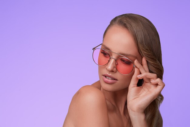 Porträt der schönen jungen Frau, die rote Sonnenbrille trägt. Sinnliches Model