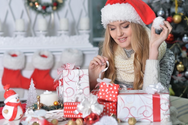 Porträt der schönen jungen Frau, die sich zu Hause auf Weihnachten vorbereitet