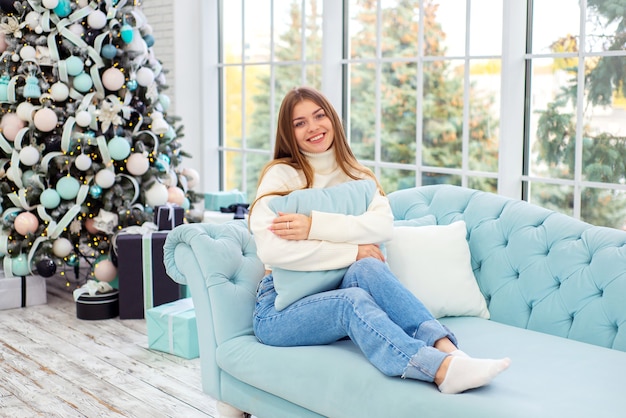 Porträt der schönen jungen Frau in Weihnachten zu Hause auf dem Sofa