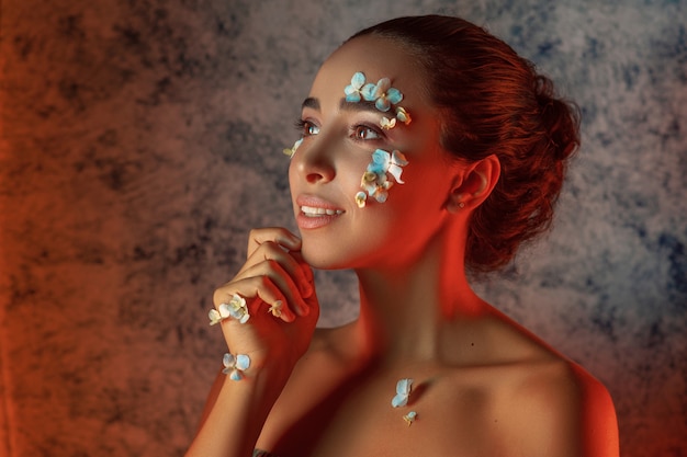 Porträt der schönen jungen Frau mit blauen Blumen