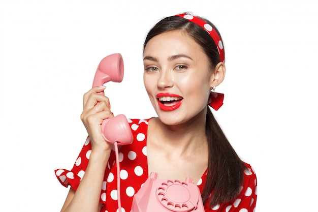 Porträt der schönen jungen frau mit dem telefon, gekleidet in der pin-up-style.