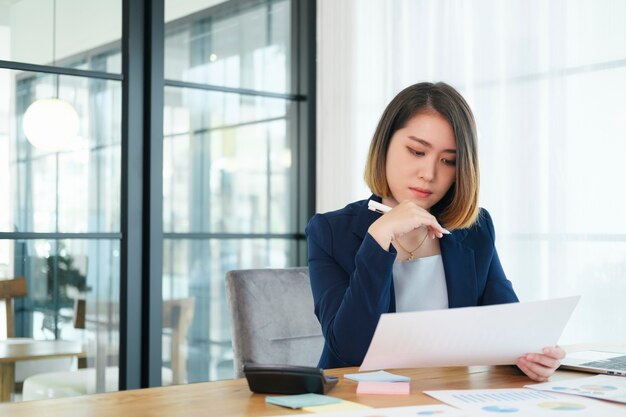 Porträt der schönen jungen Unternehmergeschäftsfrau, die im modernen Arbeitsplatz arbeitet.