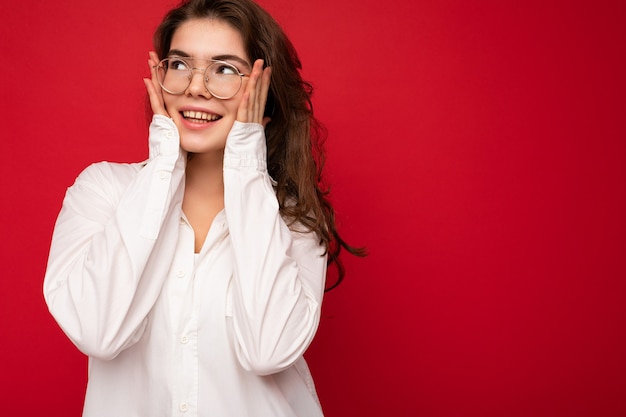 Porträt der schönen positiven fröhlichen netten lächelnden jungen Brunettefrau im zufälligen weißen Hemd