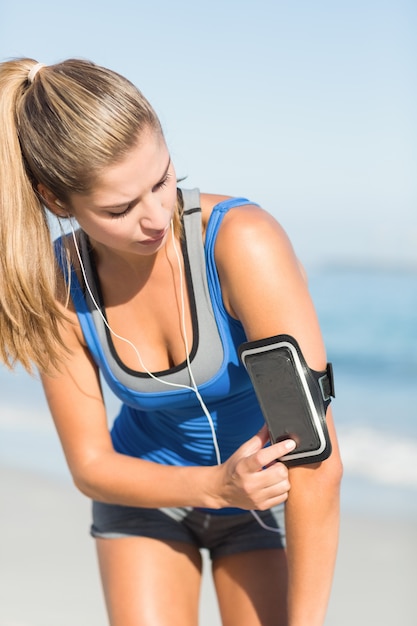 Porträt der schönen Sitzfrau, die ihr Telefon verwendet