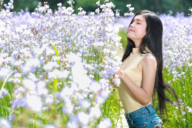 Porträt der Schönheit eine glückliche Zeit habend und unter Blume Naga-mit Haube Feld in der Natur genießend