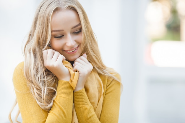 Porträt der sehr attraktiven jungen Frau im Freien. Schöne blonde Dame am städtischen Hintergrund. Stilvolles weibliches Nahaufnahmeporträt.