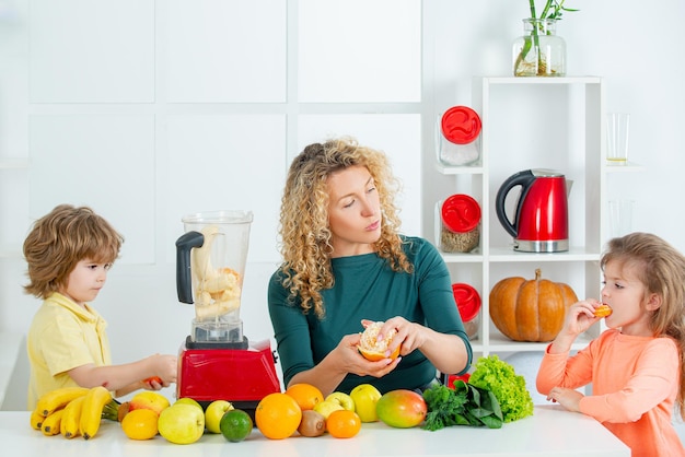 Porträt der süßen Familie macht Fruchtsaft auf weißer Küche gesundes Essen zu Hause