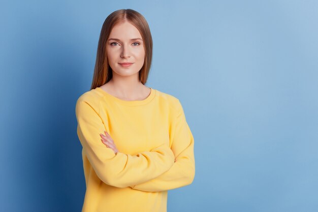 Porträt der süßen selbstbewussten Geschäftsfrau mit gekreuzten Händen schauen Kamera auf blauem Hintergrund