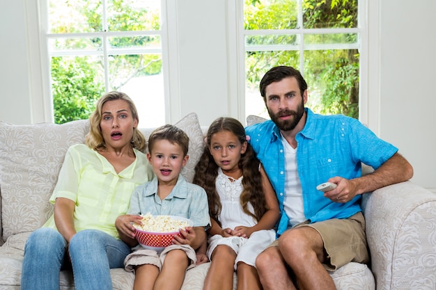 Porträt der überraschten Familie lachend beim Fernsehen