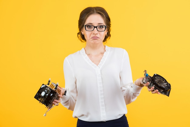 Porträt der überzeugten schönen verwirrten verwirrten jungen Geschäftsfrau mit Ausrüstungscomputerteilen