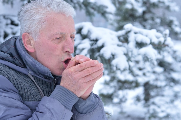 Porträt des älteren Mannes in warmer Kleidung draußen im Winter