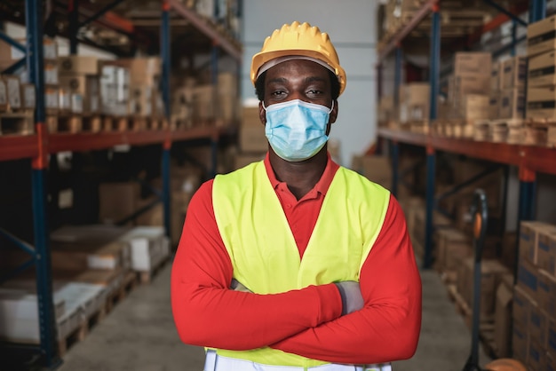 Porträt des afrikanischen Arbeiters Mann innerhalb des Lagers beim Tragen der Sicherheitsmaske - Fokus auf Mannaugen