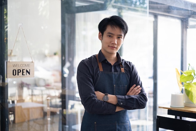 Porträt des asiatischen Barista-Cafébesitzers lächelt, während das Café das Geschäftskonzept des KMU-Unternehmerverkäufers öffnet