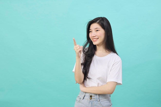 Porträt des asiatischen jugendlich schönen Lächelns der jungen Frau, das Punktfingerseite weg leeren Kopienraum lacht