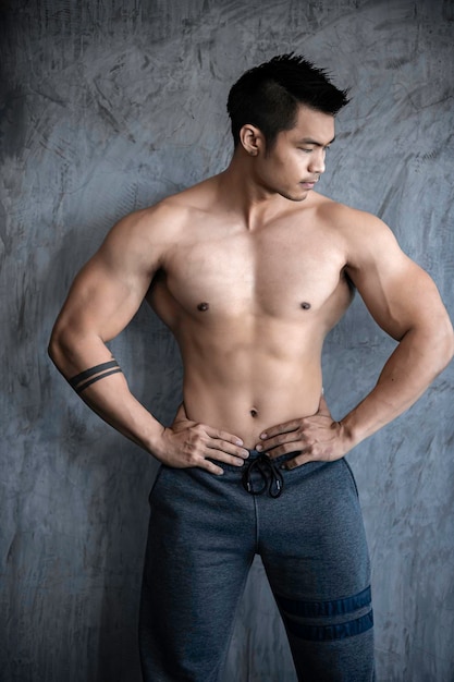 Porträt des asiatischen Mannes großer Muskel im FitnessstudioThailänderTraining für ein gutes gesundesKörpergewichtstrainingFitness im Fitnessstudio-Konzept