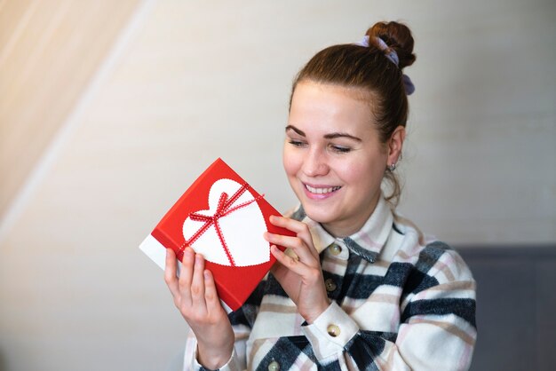 Porträt des aufgeregten niedlichen Mädchens, das in den Händen Geschenkbox hält