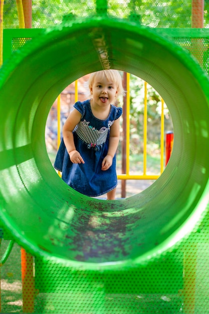 Porträt des Babys 1-2 Jahre alt. Glückliches kaukasisches Kindermädchen, das Spielzeug am Spielplatz spielt. Mädchen lächelt. Kinder- und Sportkonzept.