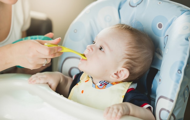 Porträt des Babys, das Püree vom Löffel isst