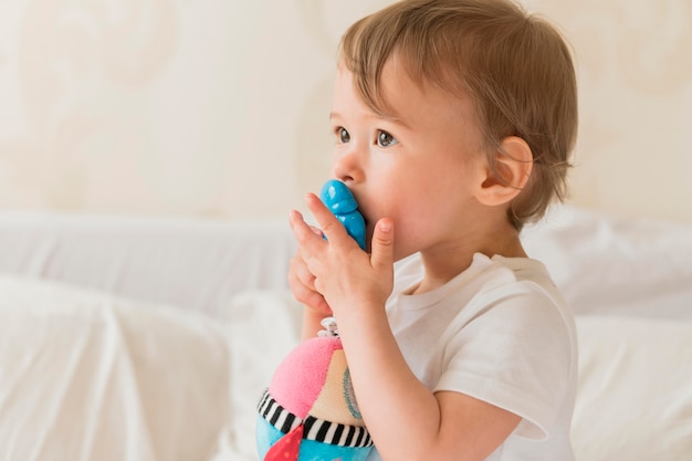 Foto porträt des babys, das spielzeug küsst