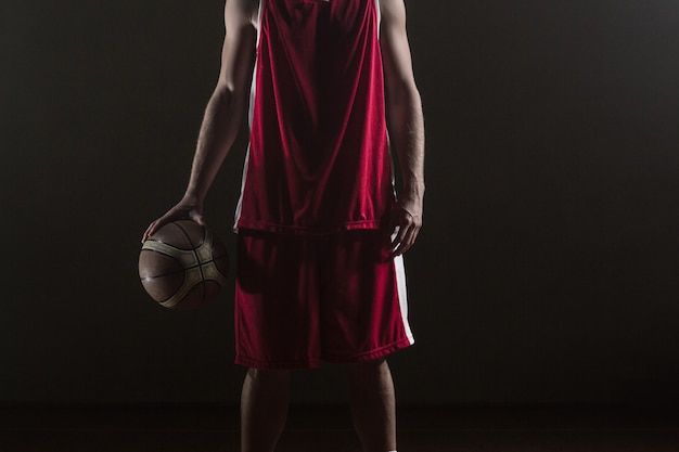 Porträt des Basketball-Spielers eine Kugel anhalten