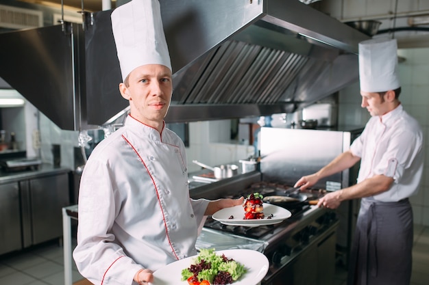 Porträt des Chefs in der Küche des Restaurants mit einem Fertiggericht Foie Gras.