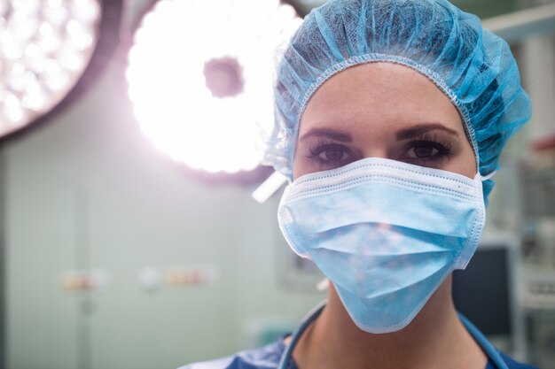 Porträt des Chirurgen, der chirurgische Maske im Operationssaal trägt