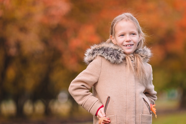 Porträt des entzückenden kleinen Mädchens draußen am schönen Herbsttag