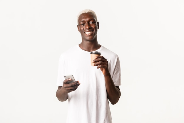 Porträt des fröhlichen afroamerikanischen Mannes, der Kaffee trinkt