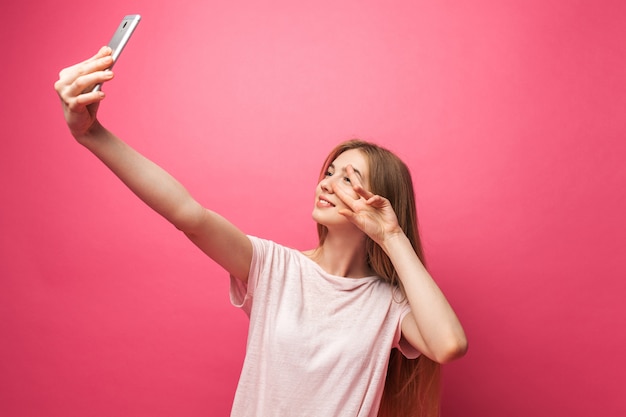 Porträt des fröhlichen schönen Mädchens, fotografiert, Selfie nehmend