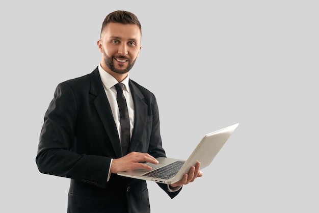 Porträt des Geschäftsmannes, der auf Laptop schreibt