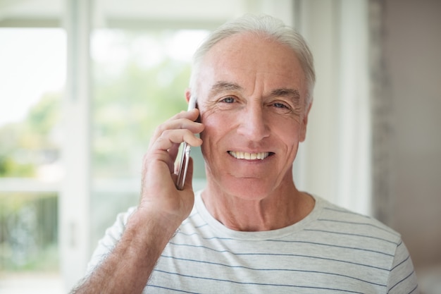 Porträt des glücklichen älteren Mannes, der auf Handy spricht