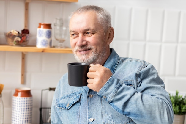 Porträt des glücklichen älteren Mannes mit Tasse Kaffee