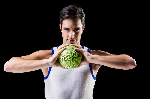 Porträt des glücklichen Athletenmannes, der Ball hält