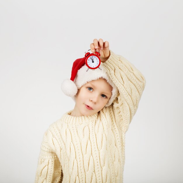 Porträt des glücklichen freudigen schönen kleinen Jungen, der Weihnachtsmannmütze trägt