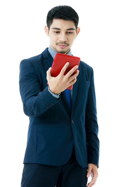 Porträt des glücklichen jungen asiatischen Geschäftsmannes, der Tablette auf lokalisiertem weißem Hintergrund verwendet. Studioaufnahme, Online-Kommunikationskonzept für Unternehmen.