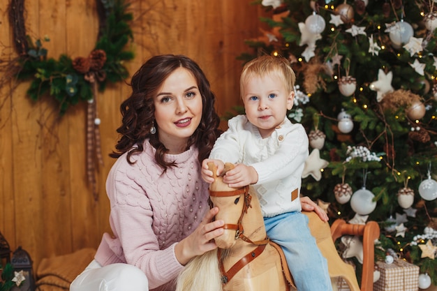 Porträt des glücklichen Jungen der Mutter und des Sohnes. Weihnachtsdekorationen