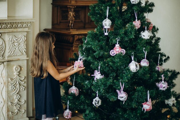 Porträt des glücklichen Mädchens Weihnachtsbaum verzierend