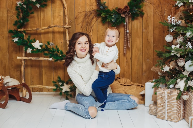 Porträt des glücklichen Mutter- und Sohnbabys. Weihnachtsdekorationen