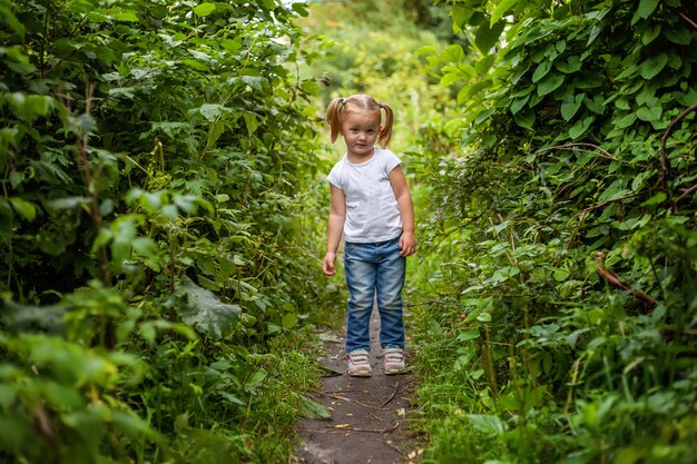 Porträt des glücklichen niedlichen kleinen Mädchens im Freien Kind, das im Parkgarten-Feenwald spielt