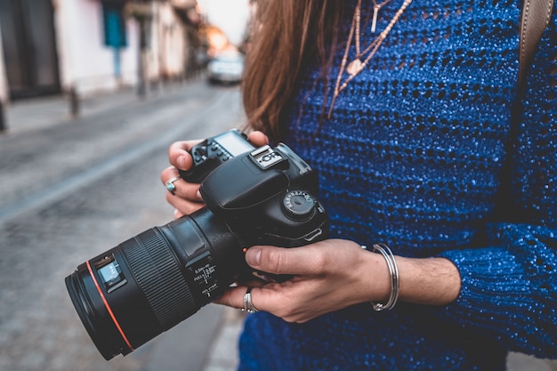 Porträt des glücklichen schönen Fotografen mit Kamera an der Straße