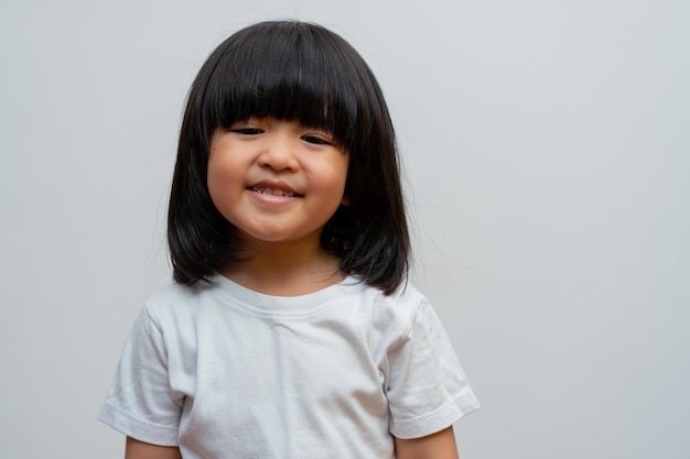 Porträt des glücklichen und lustigen asiatischen Kindermädchens auf weißem Hintergrund ein Kind, das Kamera betrachtet