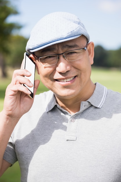 Porträt des Golfers, der lächelt und anruft