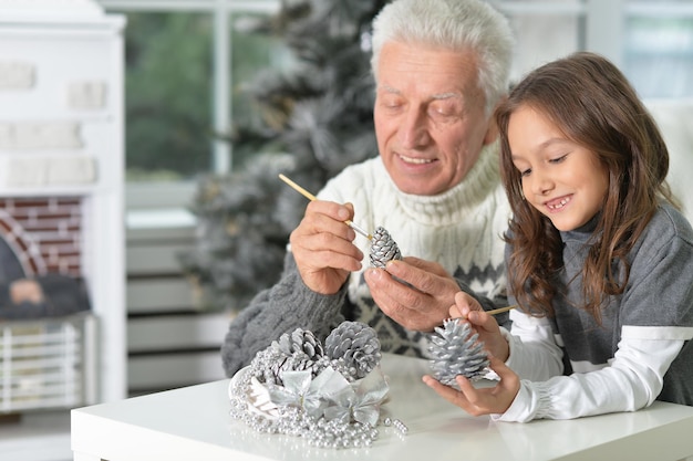 Porträt des Großvaters mit Kindermädchen, das sich zusammen auf Weihnachten vorbereitet