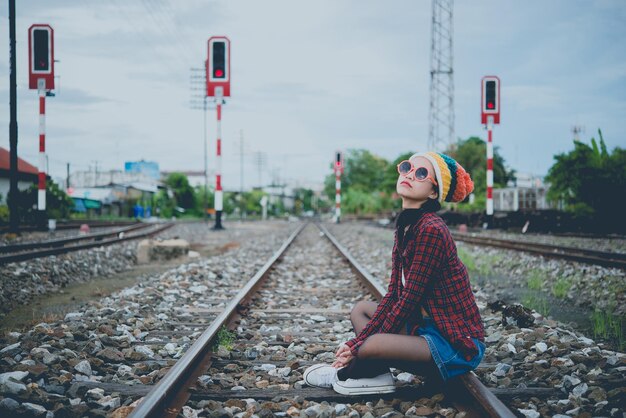 Porträt des Hipster-Mädchens sitzen auf der Eisenbahn im Vintage-Stil Thai-Frau posiert für ein Foto
