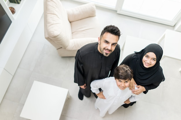 Porträt des hohen Winkels der glücklichen arabischen moslemischen Familie am neuen modernen Haus