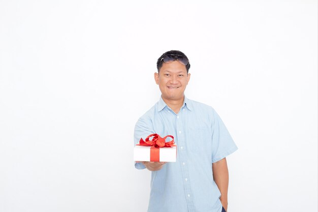 Porträt des hübschen asiatischen Mannes, der Geschenkbox hält