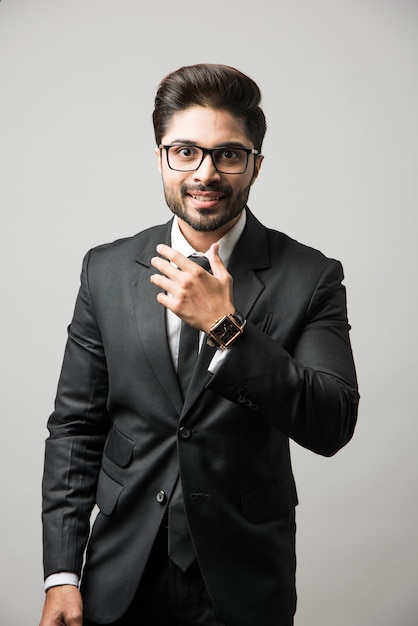 Porträt des indischen männlichen Geschäftsmannes, der auf weißem Hintergrund steht