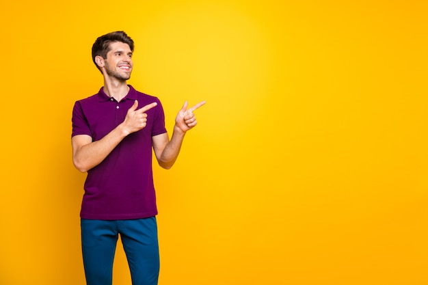 Porträt des Inhalts fröhlicher fröhlicher Kerl, der lila Hemd trägt, das zwei Zeigefinger-Anzeigenanzeige wie isoliert zeigt