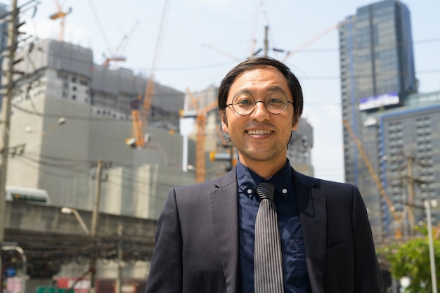 Porträt des japanischen Geschäftsmannes auf der Baustelle als industrielles Konzept