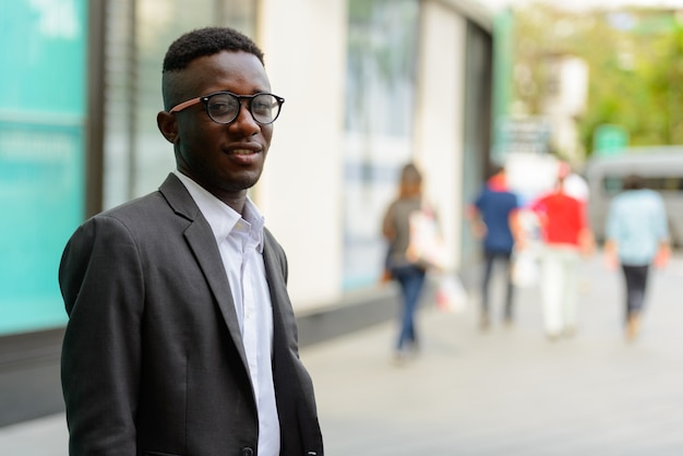 Porträt des jungen afrikanischen Geschäftsmannes in der Stadt im Freien